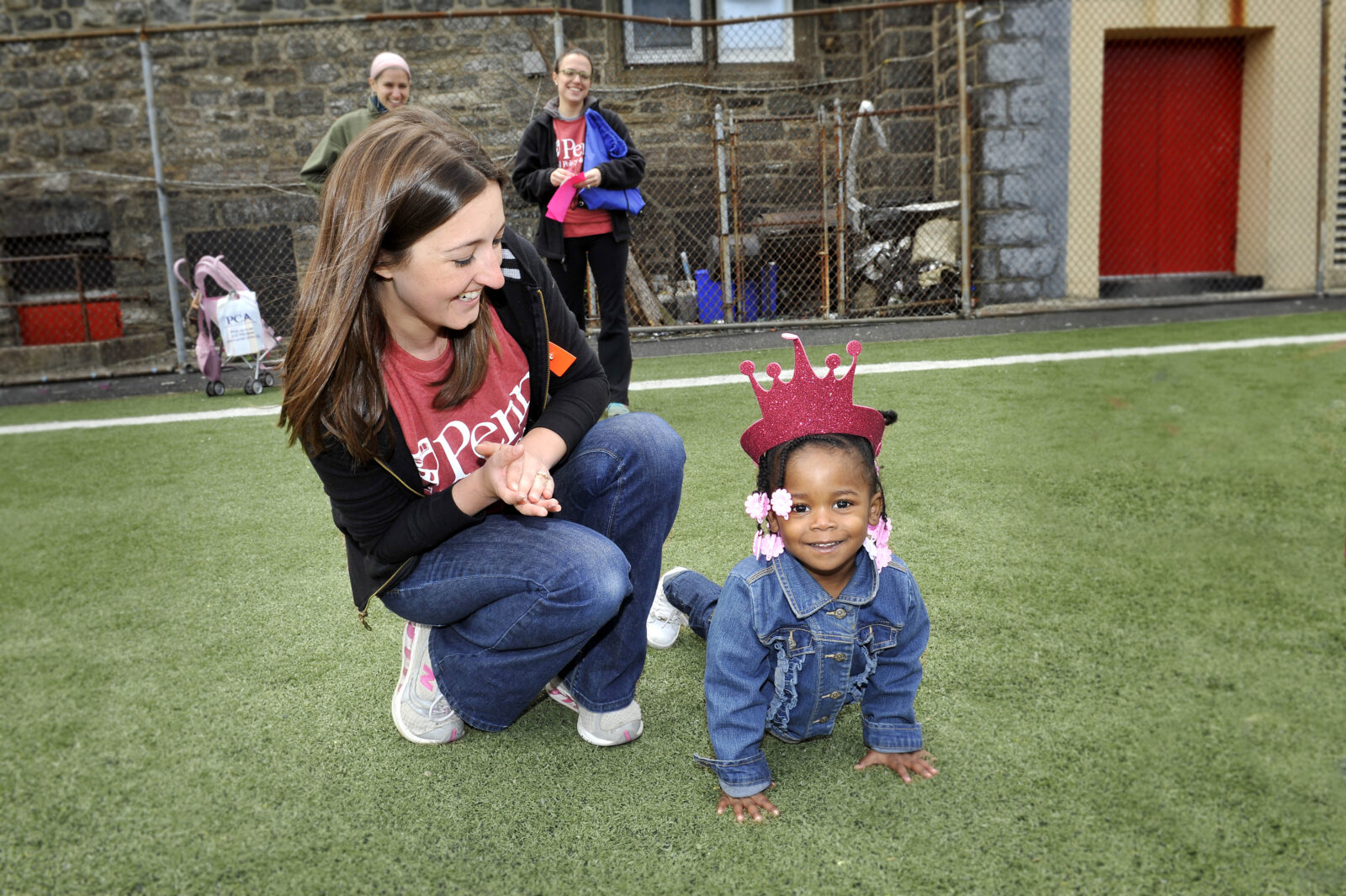 SP2 staff member sits with child in grass