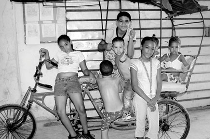 Children sit on bicycle cart