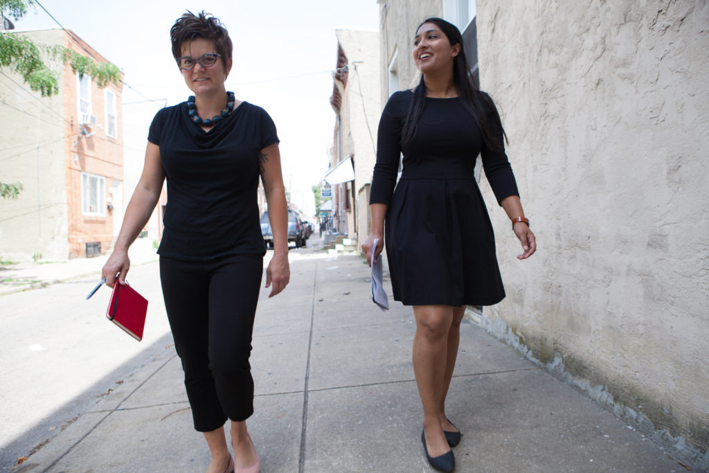 Amy Castro Baker and Henisha Patel walking along a sidewalk in South Philadelphia