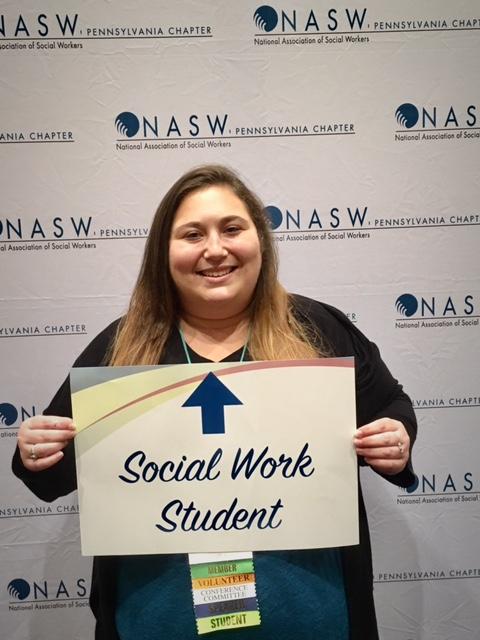 Student holds social work sign