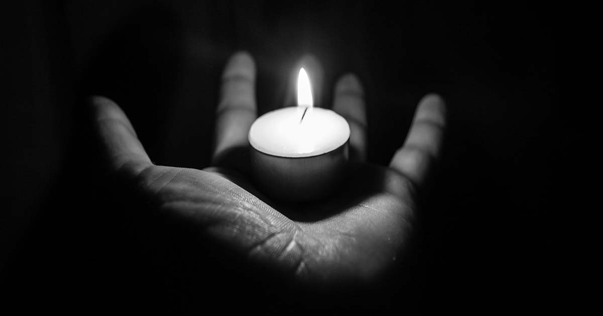 tea light reflecting on hand in the dark