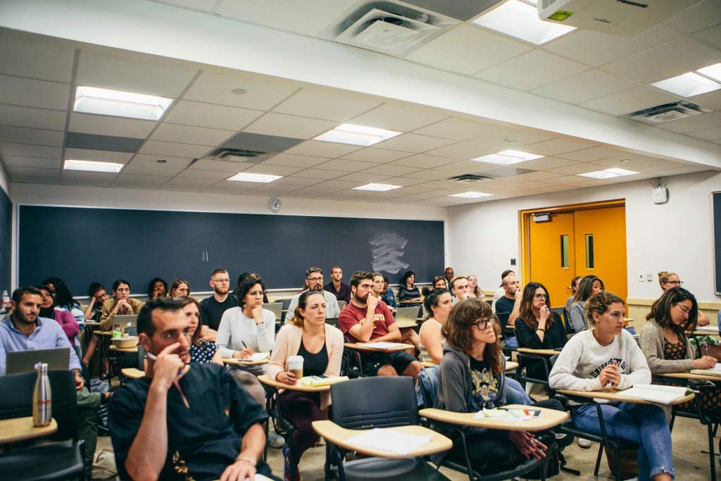 Classroom of students sitting at desks looking at front of room