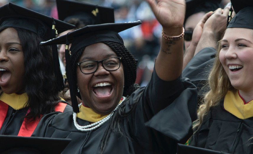 Smiling female graduate waving