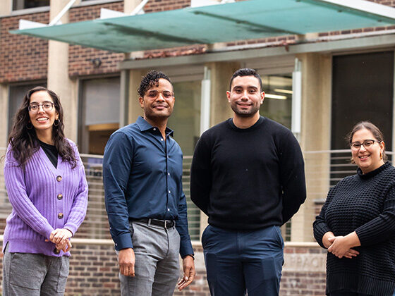 Four researchers stand in front of SP2's Caster building