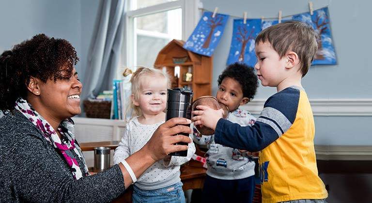 A woman and three children smile and engage in a toast