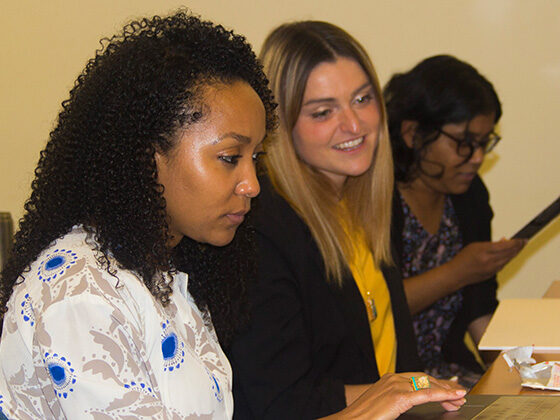 Three NPL students work at a classroom table