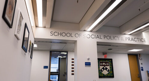 The Caster building lobby with "School of Social Policy & Practice" and artwork on the walls