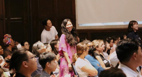 Three SP2 students stand up from their seats at Convocation