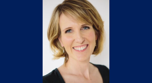 Headshot of Kerry Doyle on blue backdrop