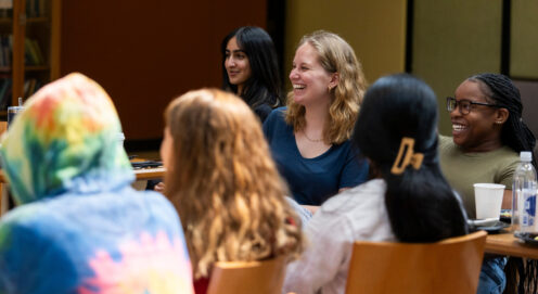 MSW students sit at tables smiling.