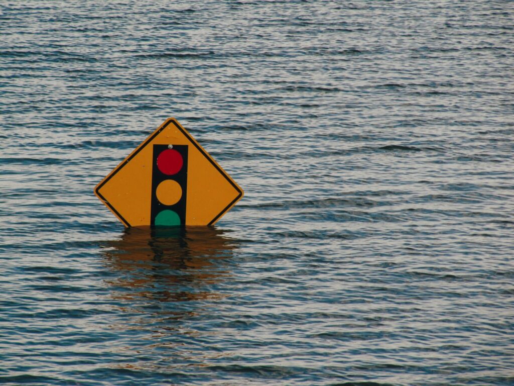 Road sign partially submerged by flood waters.