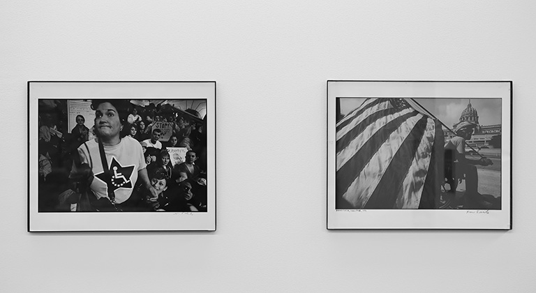 Two framed black-and-white photos of disability rights activists are displayed on the wall.