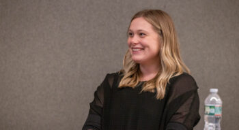 Della Jenkins smiles, sitting at a table