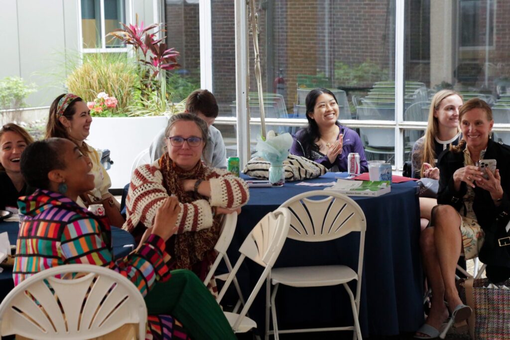 People sitting around tables and smiling at SP2's Celebrating Partnerships and Student Impact event