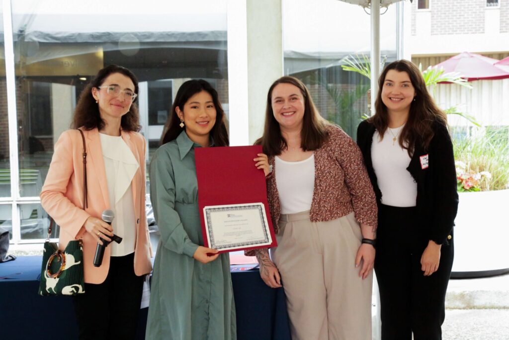 A student poses with their award certificate at SP2's Celebrating Partnerships and Student Impact event