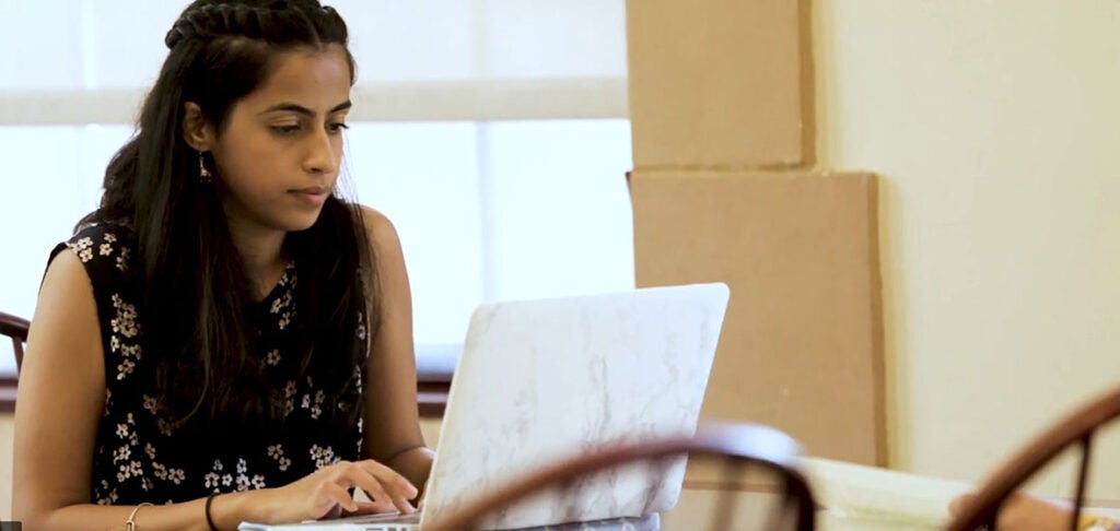 A student studying, looking intently at a computer