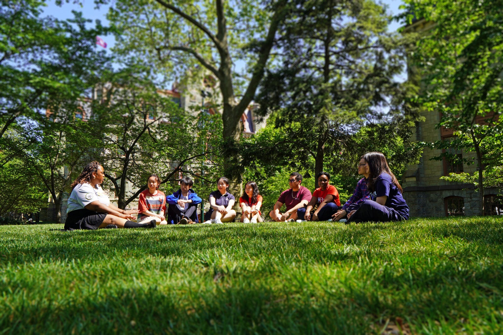 Students sitting in a semicircle on a green lawn